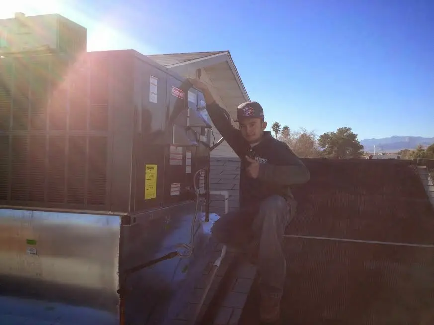 HVAC technician performing HVAC Inspection on a rooftop unit in Bellefontaine